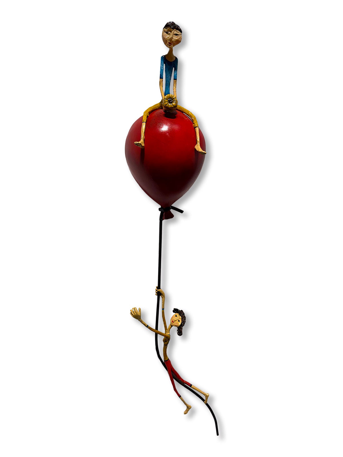 Minimalist sculpture of two figures on and hanging from a large red balloon.
