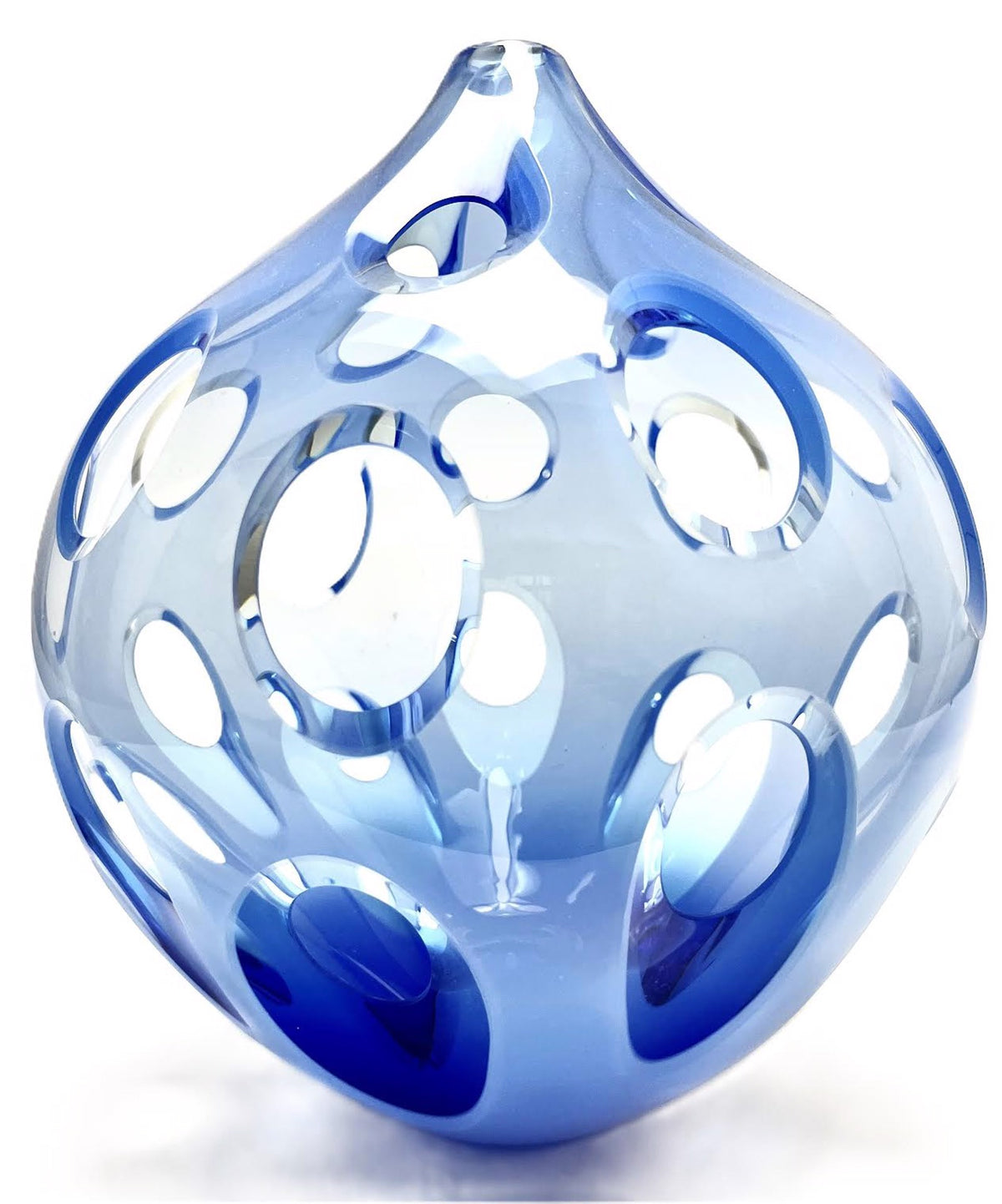 Blue glass sculpture with round cutouts on a white background.