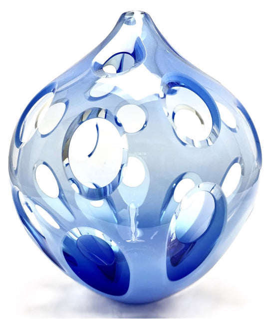 Blue glass sculpture with round cutouts on a white background.