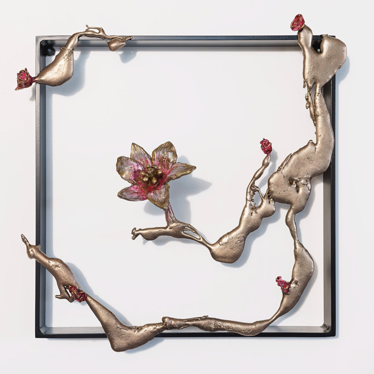 Metallic frame with organic bronze branches and pink flower accents.