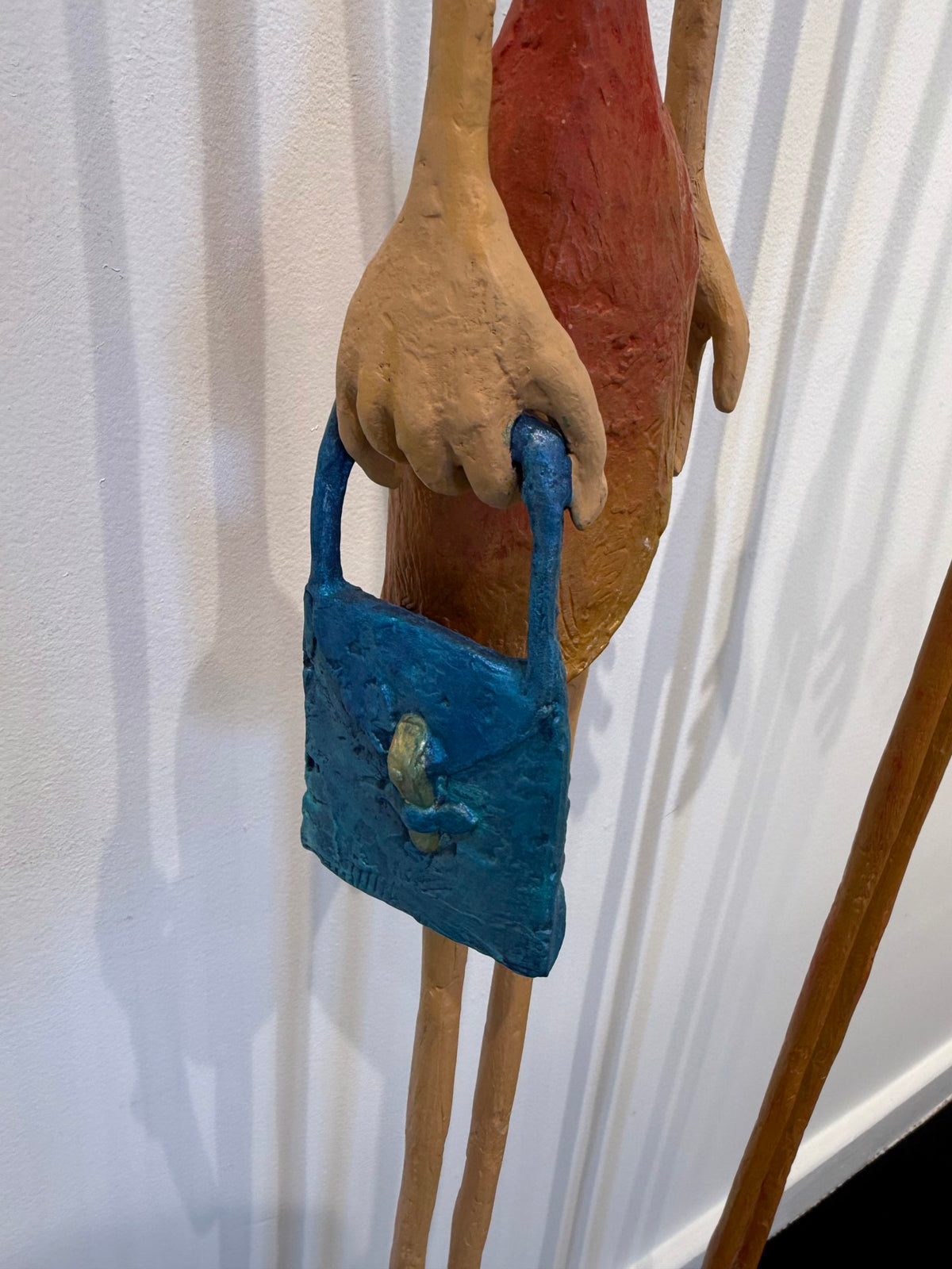 Two tall, slender wooden figure sculptures with elongated limbs on rectangular bases. (view 3)
