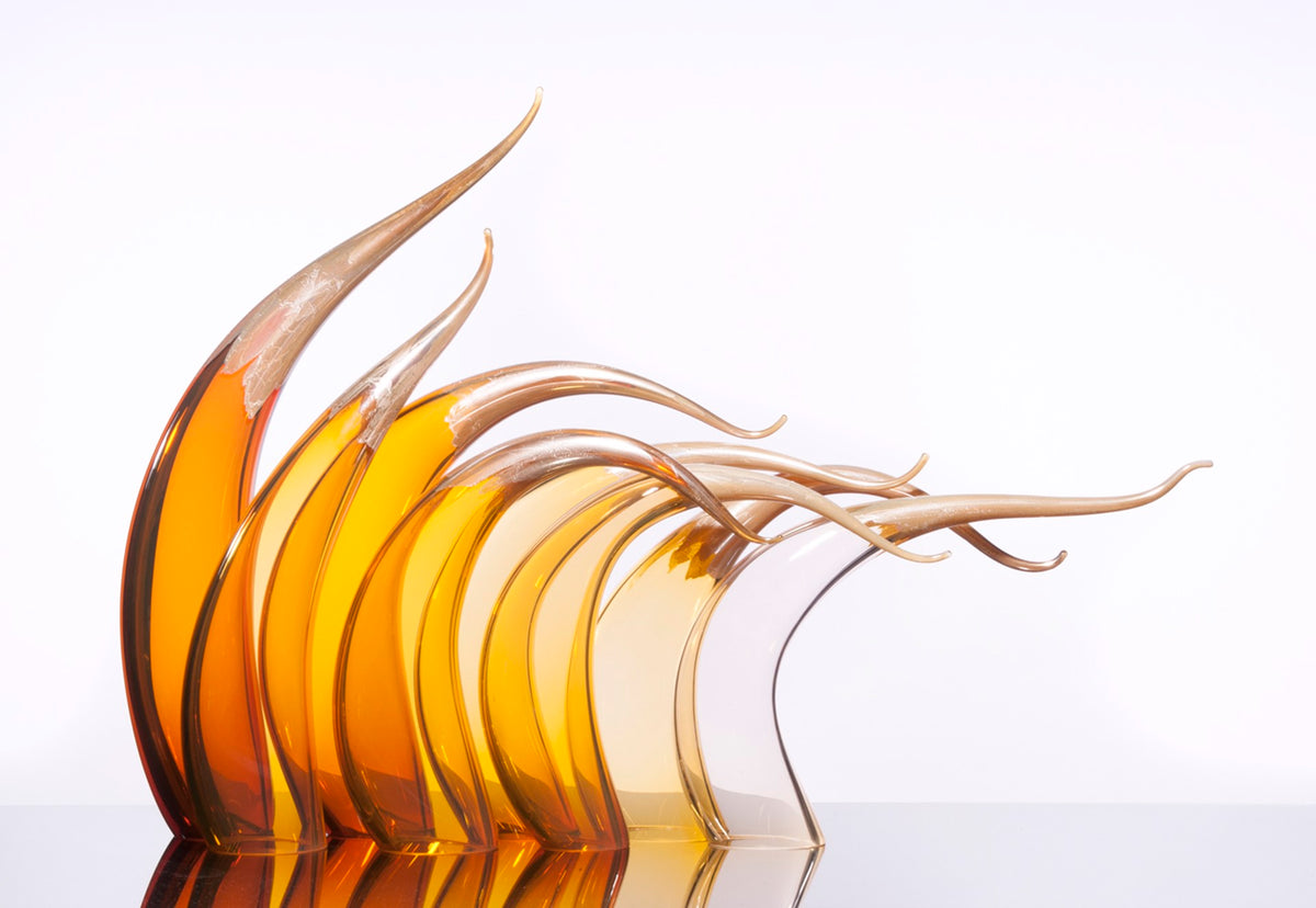 Seven abstract glass sculptures with curved, wave-like golden and amber forms.
