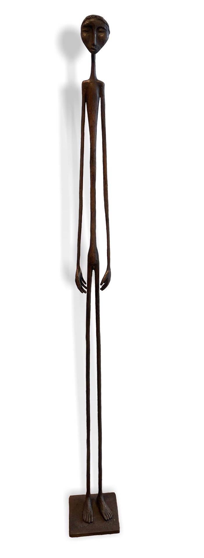 Tall, slender bronze sculpture of a human figure with elongated limbs, standing on a rectangular base. The figure has minimal facial features and an abstract, stylized form.