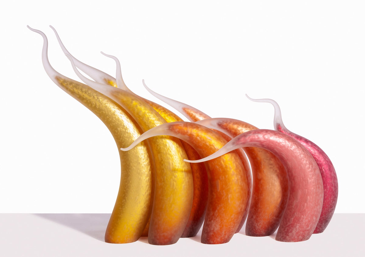Six colorful, curved glass sculptures with pointed tips on a white background.