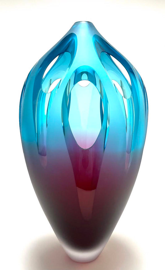 Blue-to-purple glass sculpture with oval cutouts on a white background.