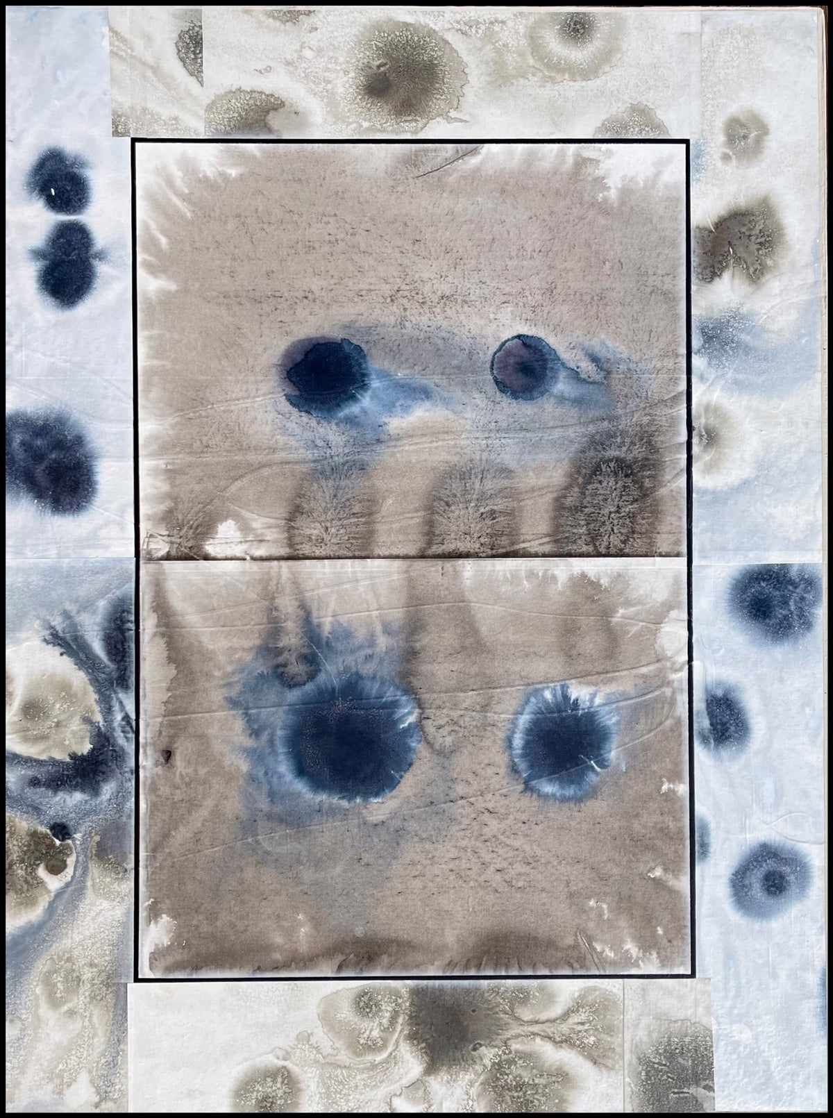 Abstract painting with blue and gray ink blotches and stains on a textured background, featuring darker circular shapes in the center and lighter spots along the edges.