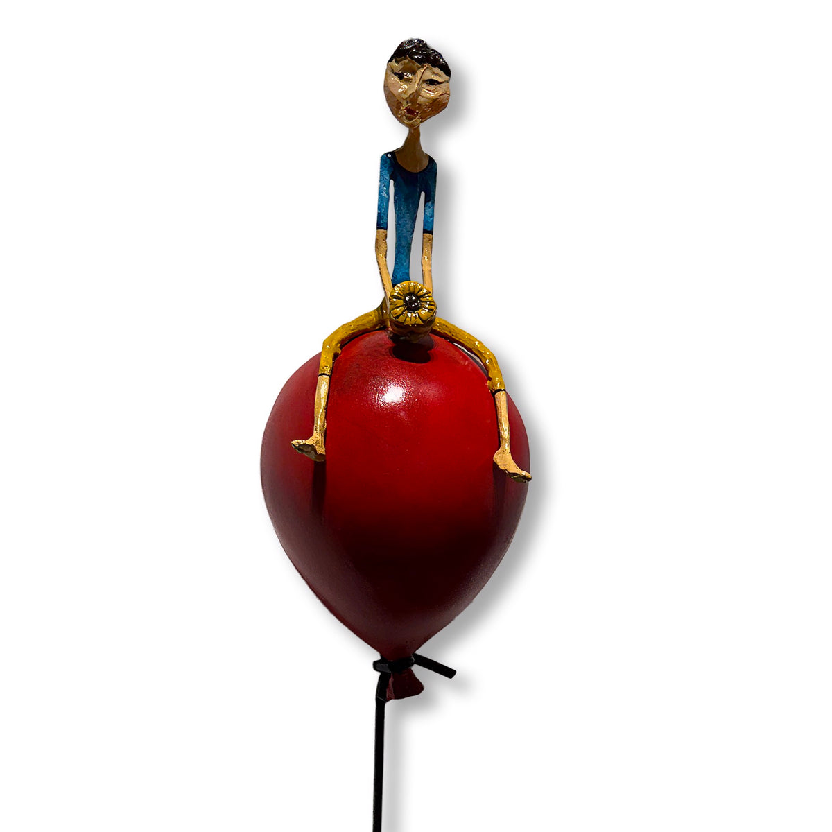 Minimalist sculpture of two figures on and hanging from a large red balloon. (view 2)