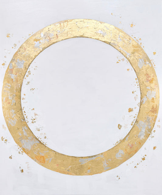 A large gold circular ring with a textured surface on a white background. Small gold and silver flakes surround the ring.