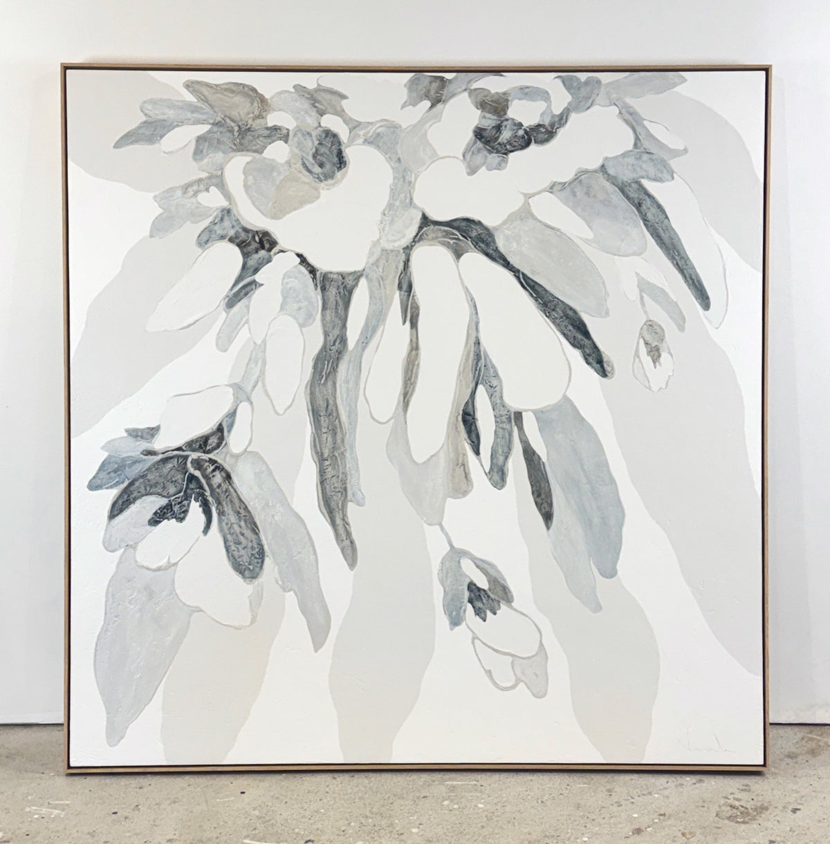 Large abstract painting of overlapping leaf-like shapes in white, gray, and black.