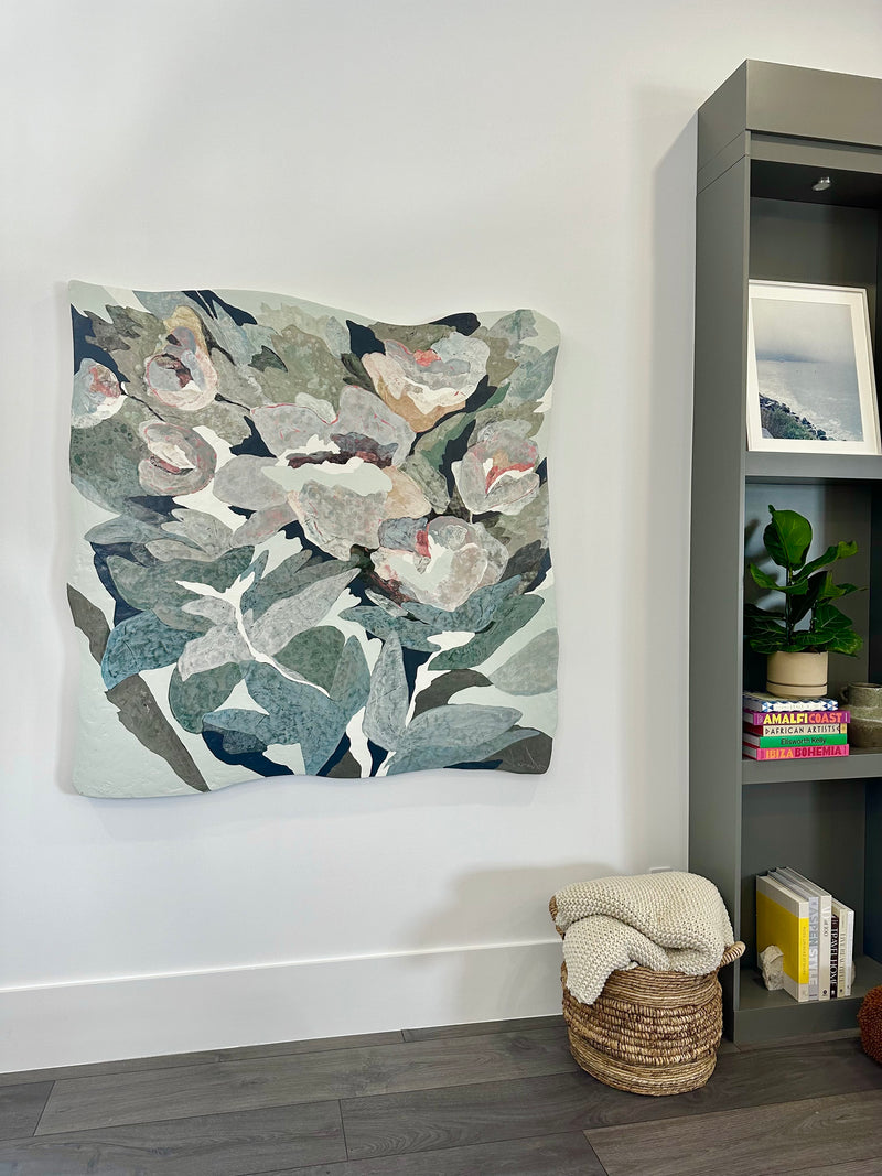 Vesela Baker gray-green and blush abstract floral painting beside a modern bookcase in a South Florida home