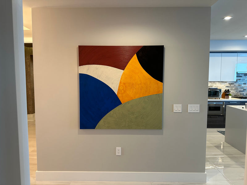 David Skillicorn bold color-block abstract in red, cobalt, orange, black and olive on a gray wall near a kitchen