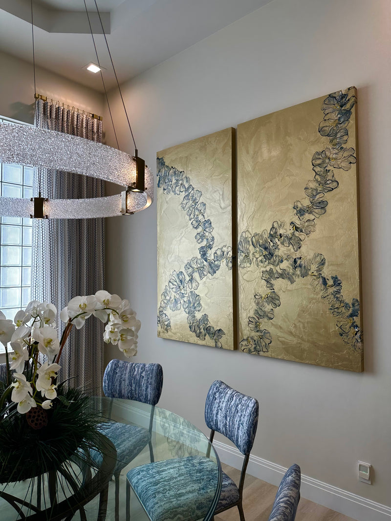 Ann Griffith gold diptych with flowing blue ribbon forms in a dining room with an orchid centerpiece