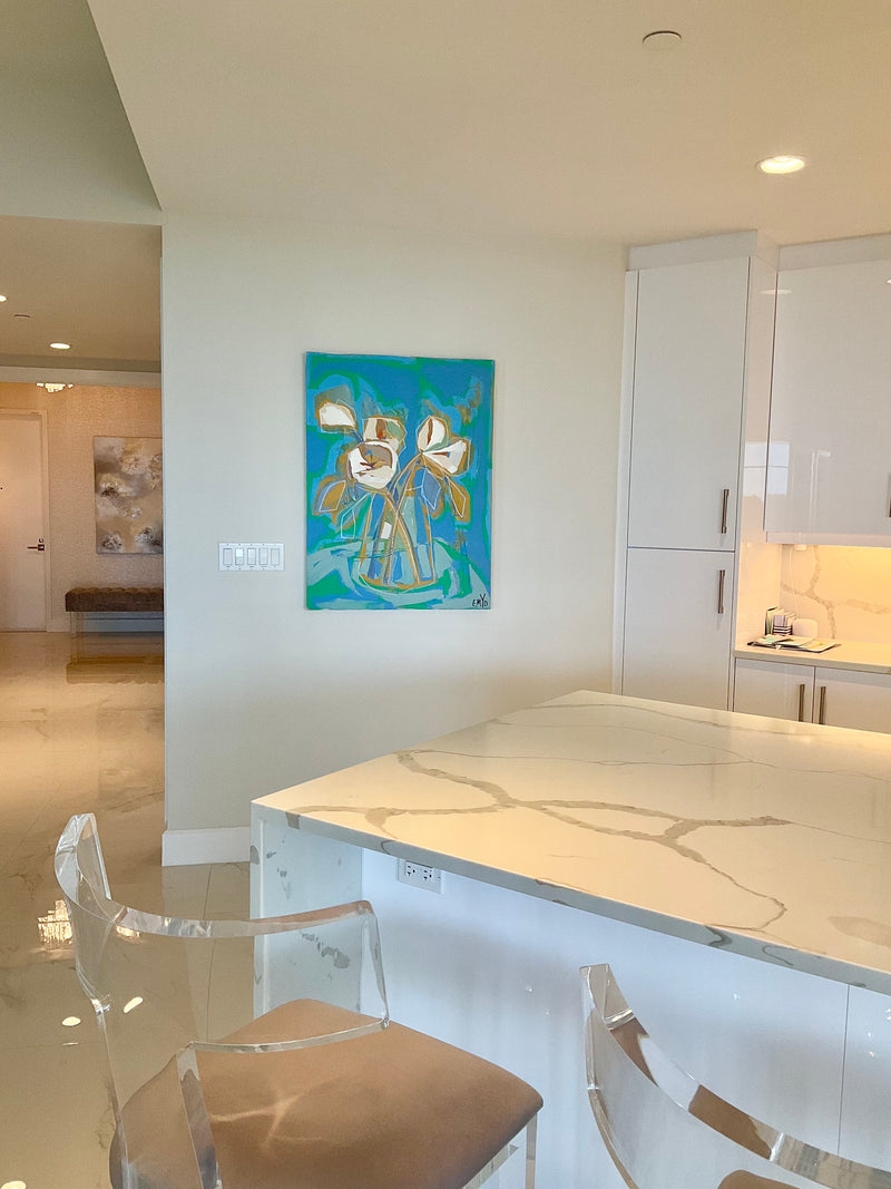 Emyo painting of white flowers in a vase on turquoise in a white kitchen with a marble island