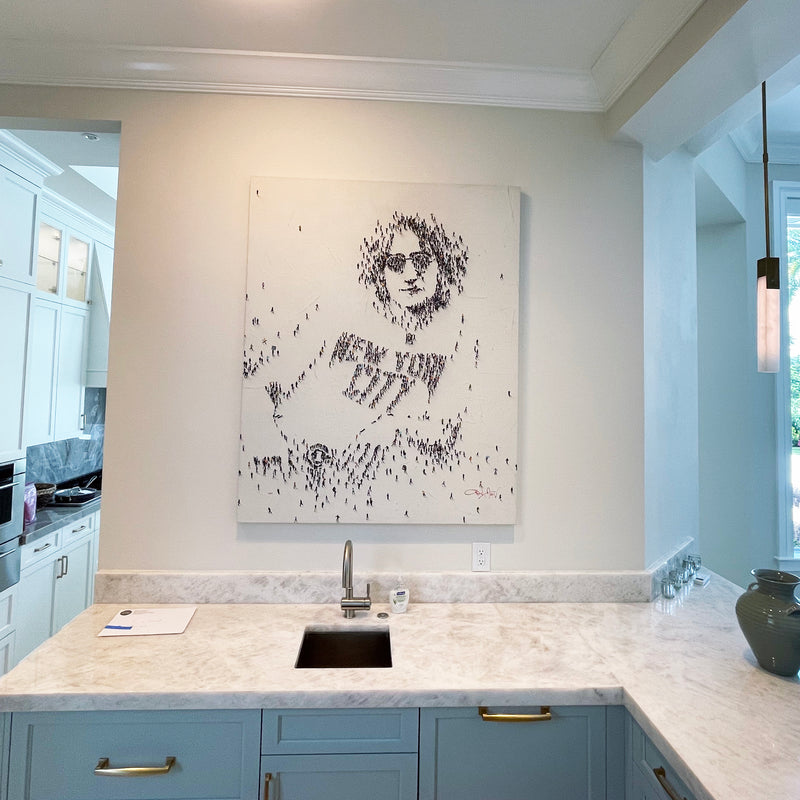 Craig Alan portrait built from tiny painted figures of a man in round glasses and a New York City shirt, wet bar