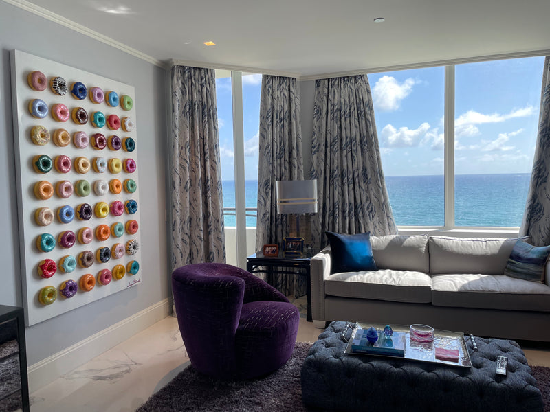 Anna Sweet wall art of rows of colorful sculpted donuts in an oceanfront condo living room with Atlantic views