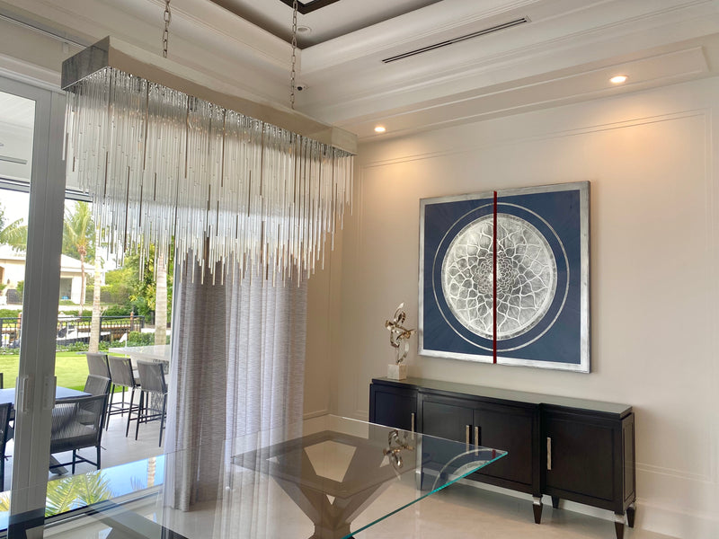 Stephanie Paige navy marble plaster artwork with a silver mandala in a dining room with a crystal chandelier