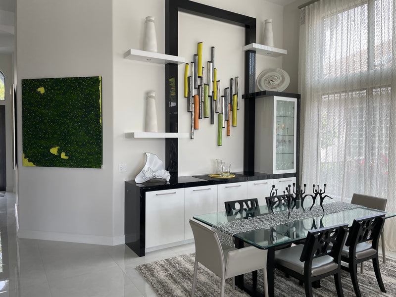 Dawn Renee metal tube wall sculpture and Vincent Lardieri green textured painting in a modern dining room