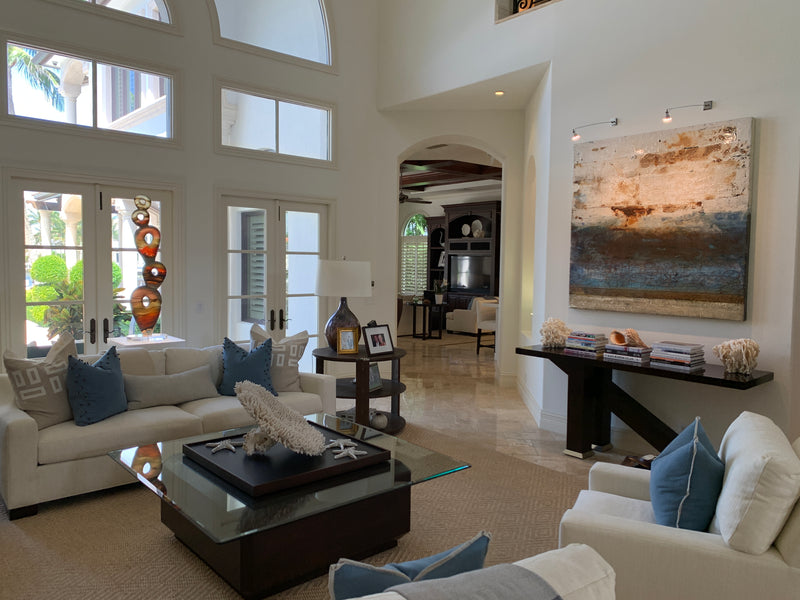 Rick Eggert stacked orange sculpture and Mike Elsass blue and rust abstract in a two-story living room