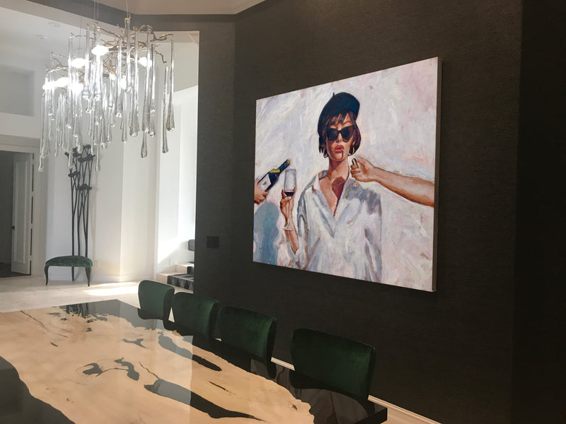 Nava Lundy painting of a woman in sunglasses and a beret holding a wine glass in a dark-walled dining room