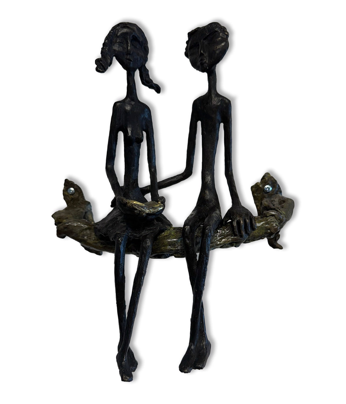 A sculpture of a couple sitting on a branch, one reading a book