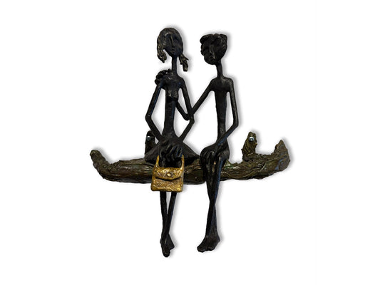 A sculpture of a couple sitting on a branch, one with a gold purse.
