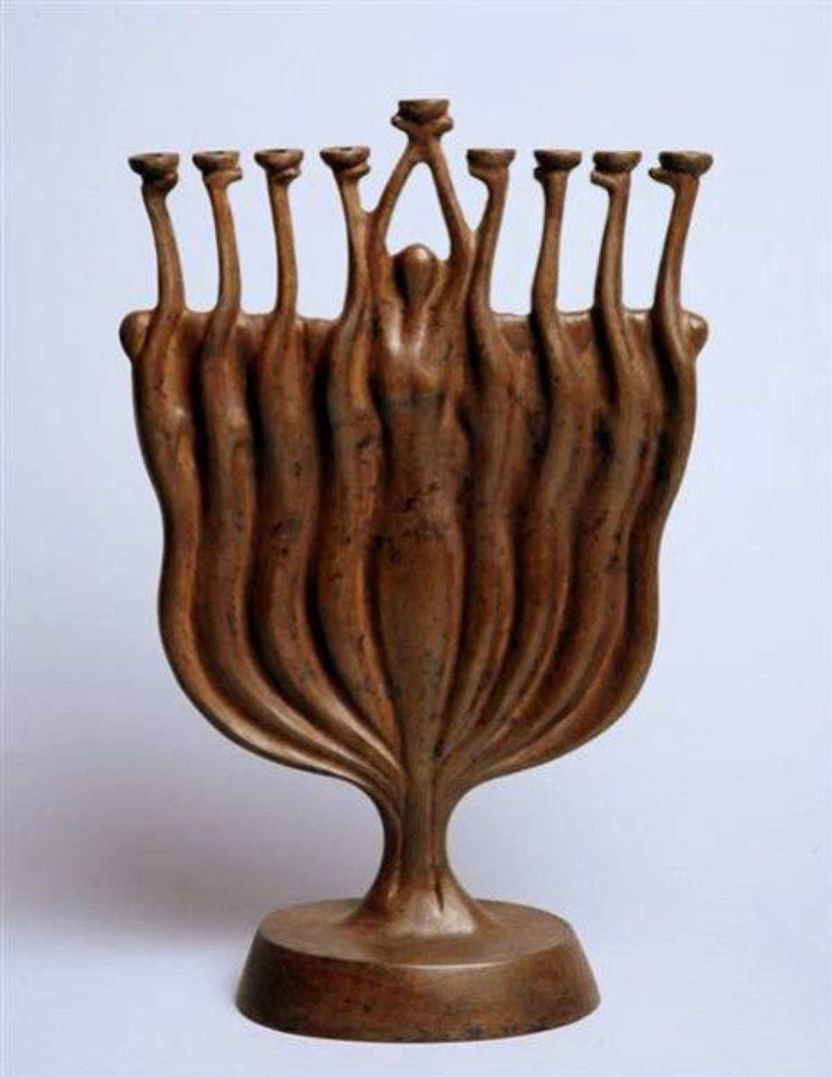 A bronze sculpture resembling a menorah with nine elongated human figures forming the branches and a central figure holding a candle holder.